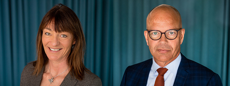 En kvinna och en man framför ett blått draperi.
